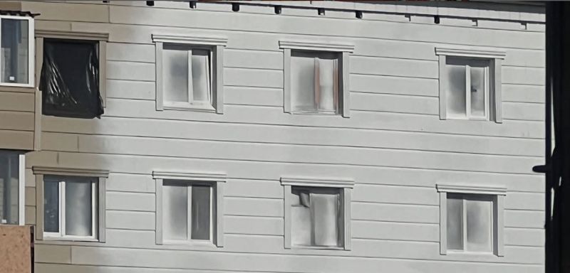 В Костанае рабочие покрасили фасад вместе с окнами: жильцы недоумевают