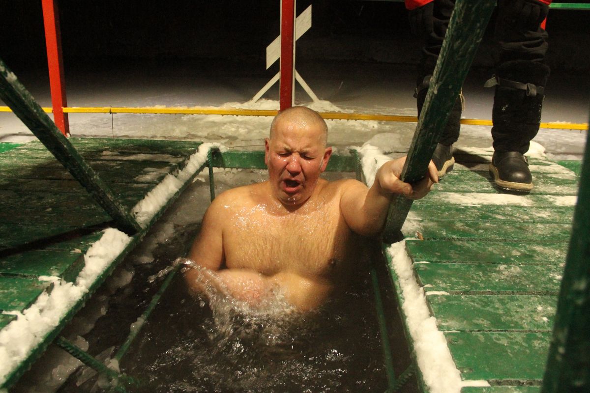 Мужчина купается на крещение