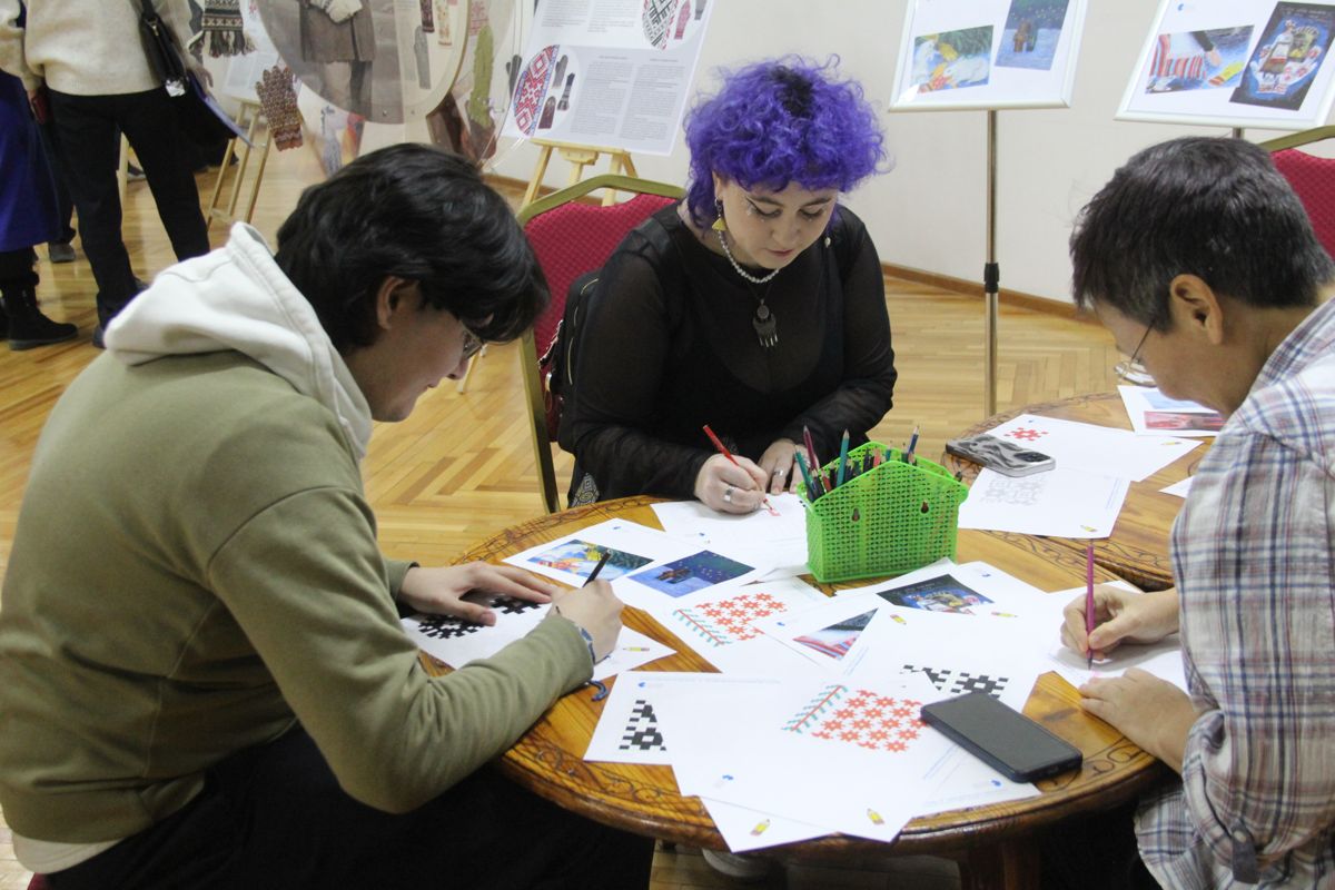 Люди рисуют на эстонской выставке рукавиц