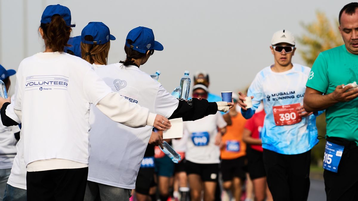 волонтёры подают стакан воды на дистанции