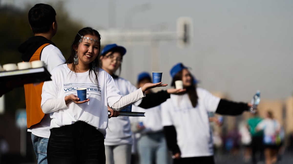 волонтёры подают стакан воды на дистанции