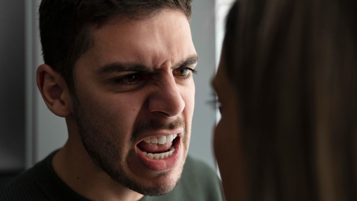 мужчина с напряжённым лицом кричит на женщину, стоящую напротив; виден конфликт