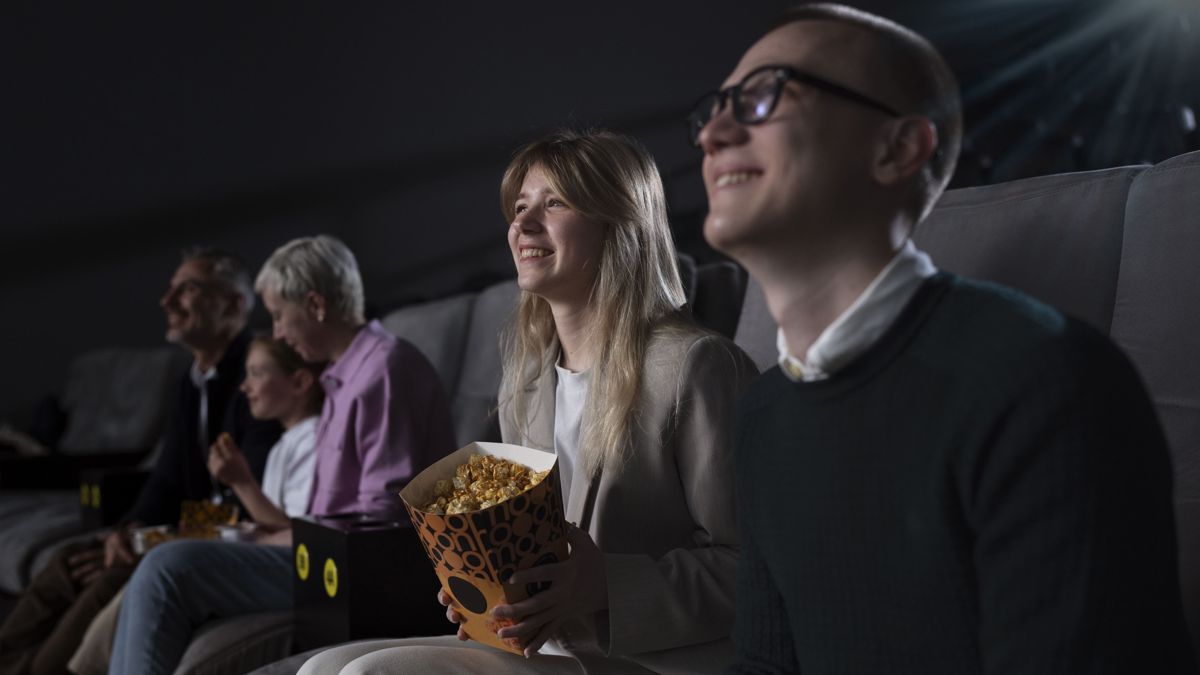 В кинозале множество зрителей смотрят фильм